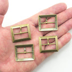 Close-up of an antique gold tone metal buckle showing detail and finish.