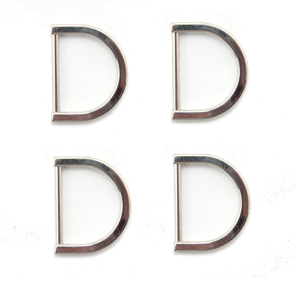 Four silver tone metal D rings displayed on a white background.