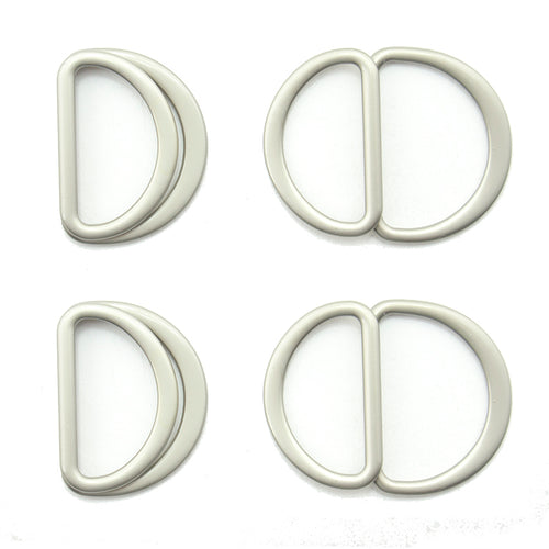 Four silver tone metal hinged D rings on a white background.