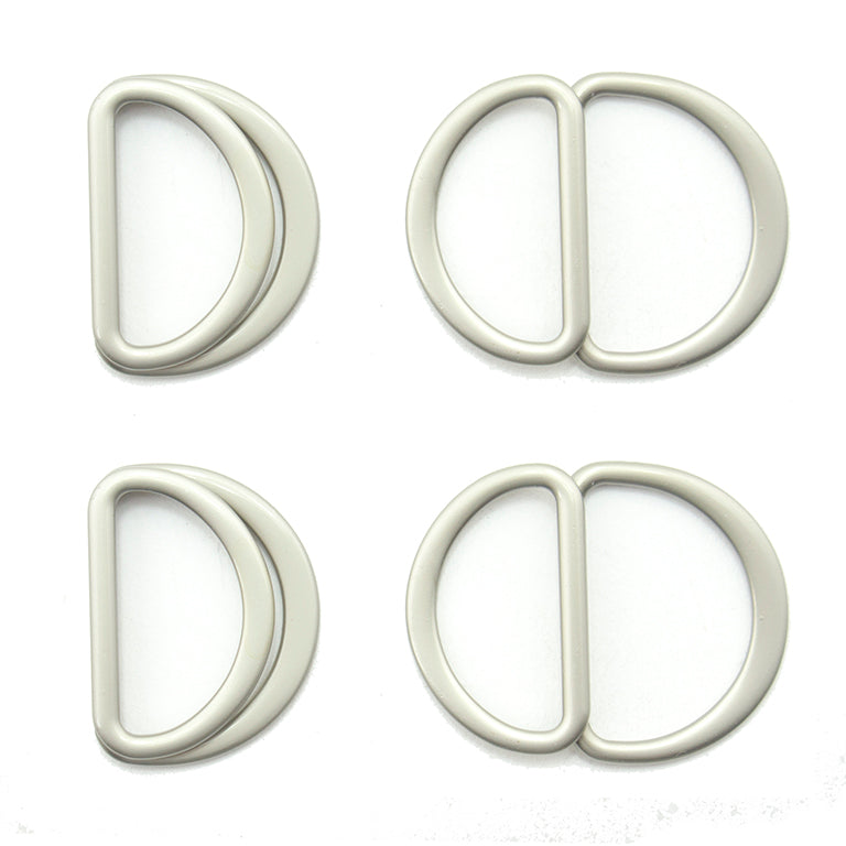 Four silver tone metal hinged D rings on a white background.