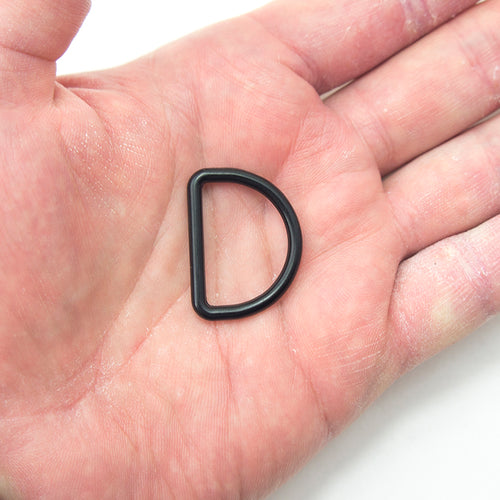 Close-up of black metal D ring showing size and finish.