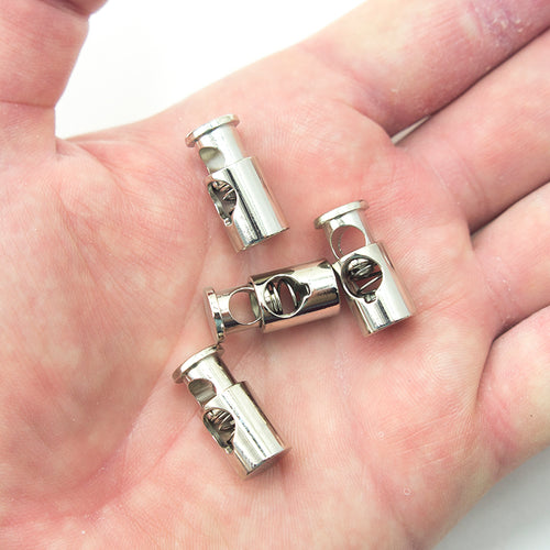 Close-up of a silver tone metal spring stop cord toggle showing size and design.