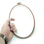 Both wood-effect oval embroidery hoops with metal hooks displayed