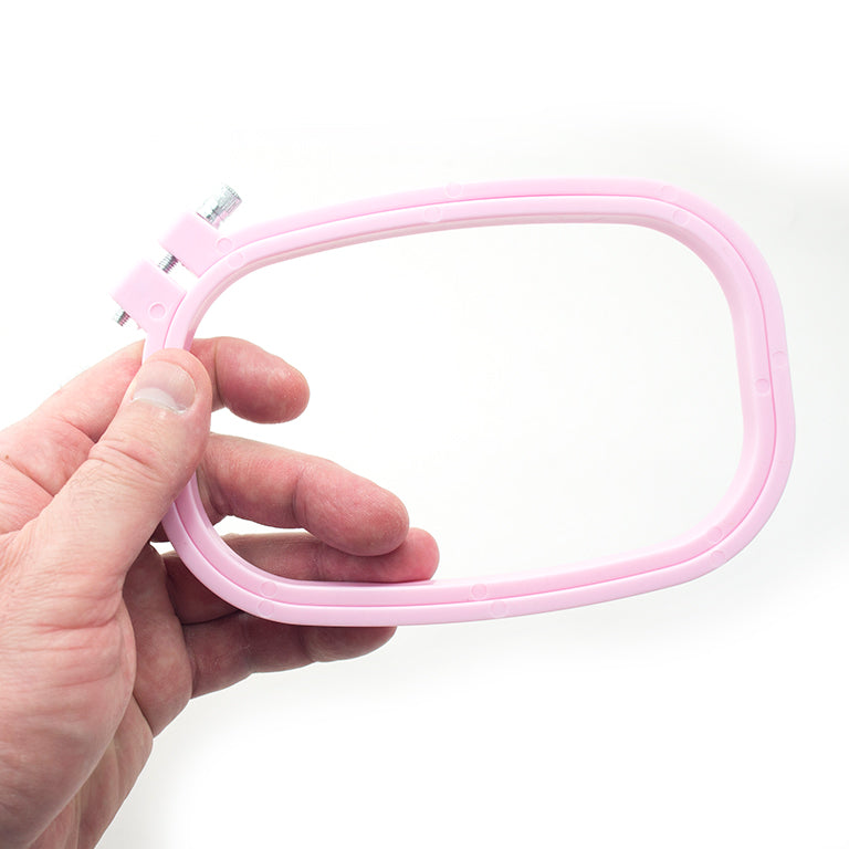 Close-up of the metal screw attachment on a plastic embroidery hoop.