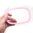 Close-up of the metal screw attachment on a plastic embroidery hoop.