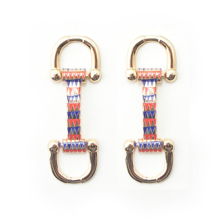 Gold tone metal equestrian buckle with red and blue pattern.