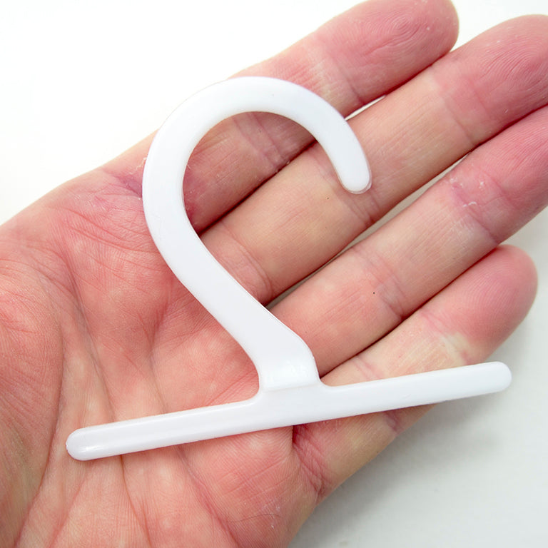 Close-up of a white plastic hanger displaying a fabric sample.