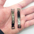Two equestrian buckles displayed, measuring 64 x 9 mm.