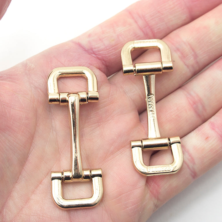 Two gold tone square metal equestrian buckles displayed together.