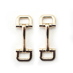 Gold tone square metal equestrian buckle on a white background.
