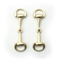 Matte gold tone metal hinged equestrian buckle on a white background.