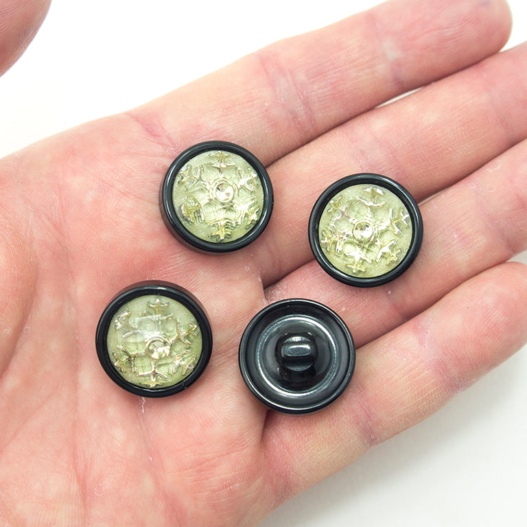 Snow flake button showing silver tone metal on black background