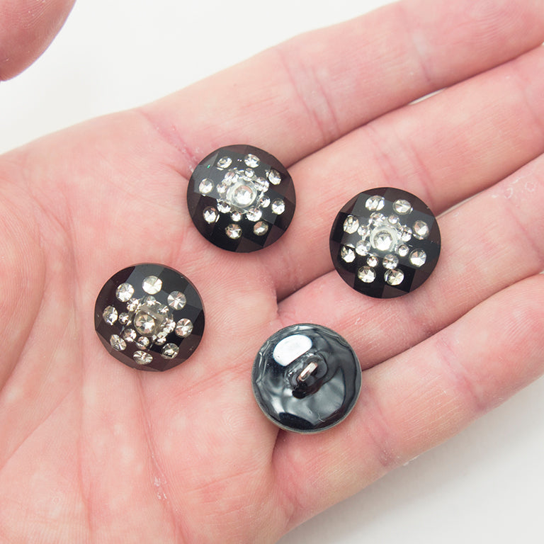 Clear crystal button displayed on a fabric background