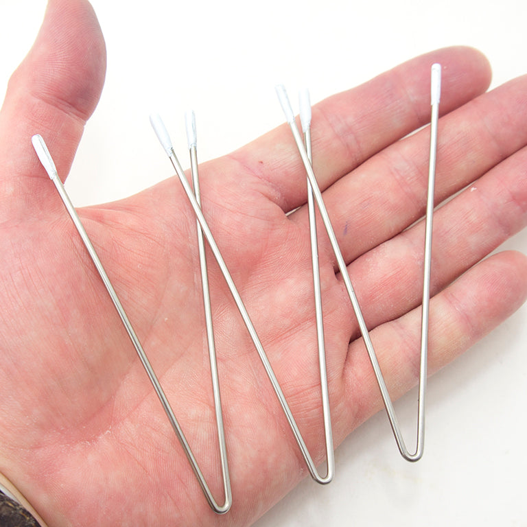 Close-up of metal V wires with white enamel tips for protection.