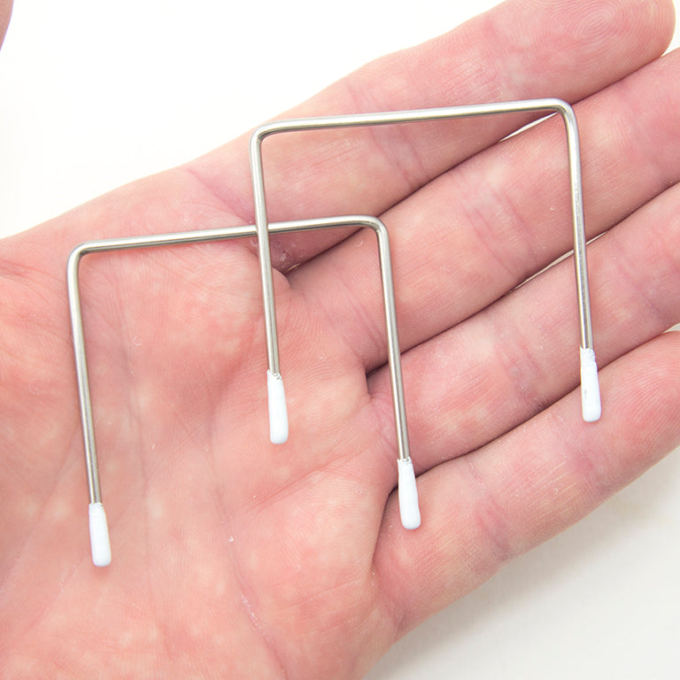 Close-up of metal square wires with white enamel tips.