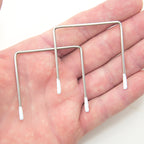 Close-up of metal square wires with white enamel tips.