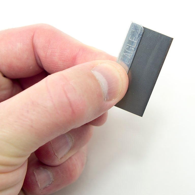 Close-up of a single edge razor blade showing the cutting edge.