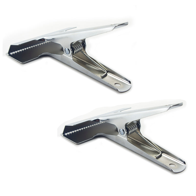 Large wide sprung cloth clamps displayed on a table