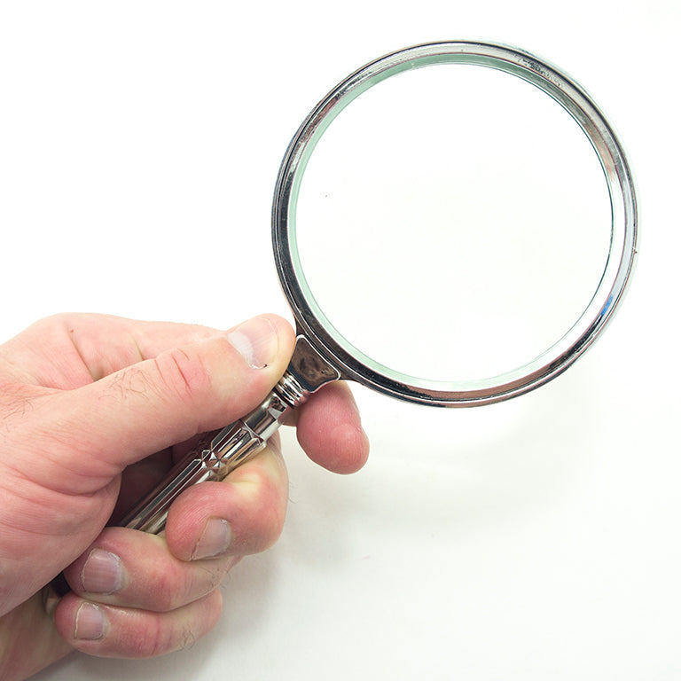 Magnifying glass displayed on a wooden surface for context.
