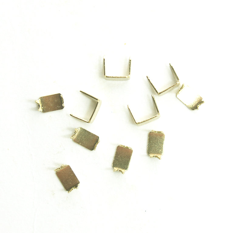 Ten gold tone brass zip stop ends for No.5 zips arranged in a pack.