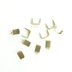 Ten gold tone brass zip stop ends for No.5 zips arranged in a pack.