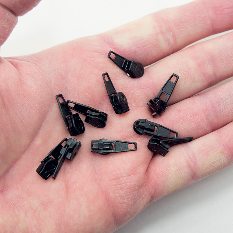 Close-up of a black metal No.3 zip pull showing its sleek design.