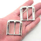 Close-up of a silver tone square buckle measuring 47 x 47 mm.