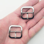 Close-up of a dark silver tone metal buckle, 33 x 33 mm.