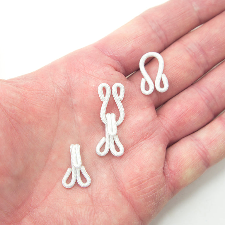 Close-up of cotton over copper hooks and eyes, showing size and finish.