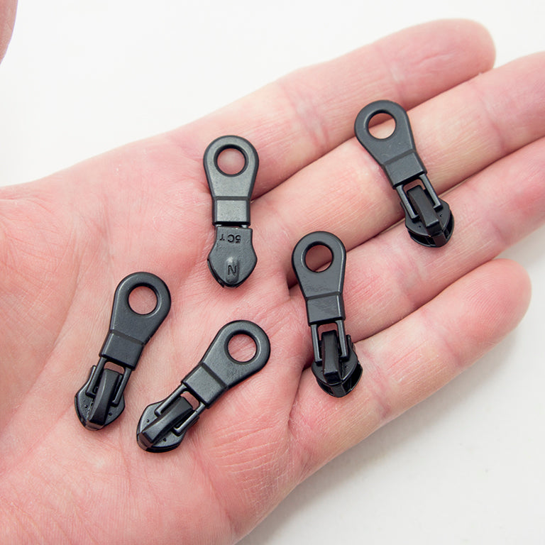 Close-up of a black metal zip pull measuring 34 x 12 mm.