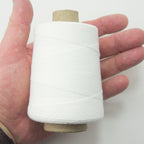 Close-up of a spool of white cotton thread, 1500 ft length.