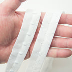 Full length view of 1 metre white bra hook and eye tape on a flat surface.
