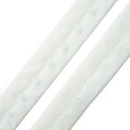 Close-up of white bra hook and eye tape showing hooks and eyes.