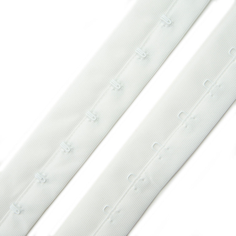 Close-up of white bra hook and eye tape showing hooks and eyes.