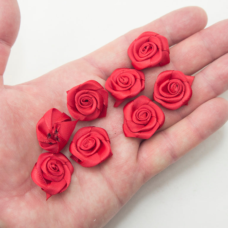 Close-up of red rose fabric flower trim, ideal for embellishments.