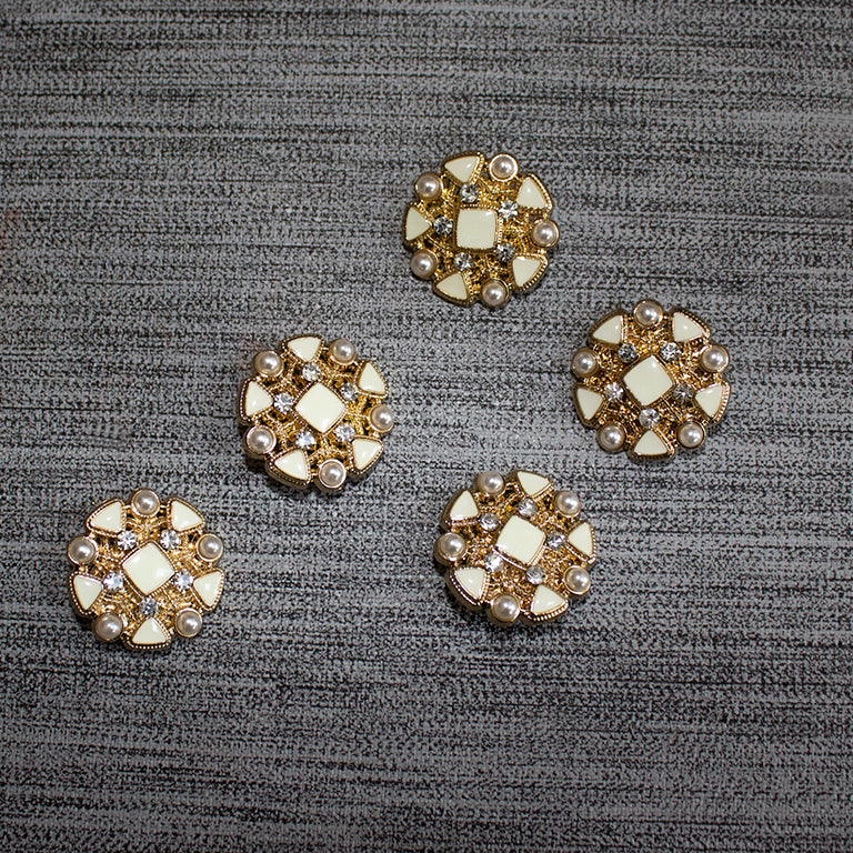 Close-up of ivory enamel button with gold tone setting