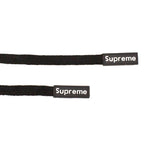 Close-up of black cotton cords showing fine weave and rubber ends.