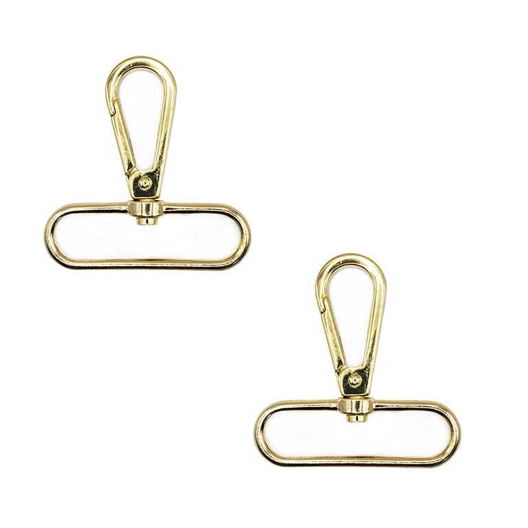 Two gold tone metal swivel clasps on a white background.