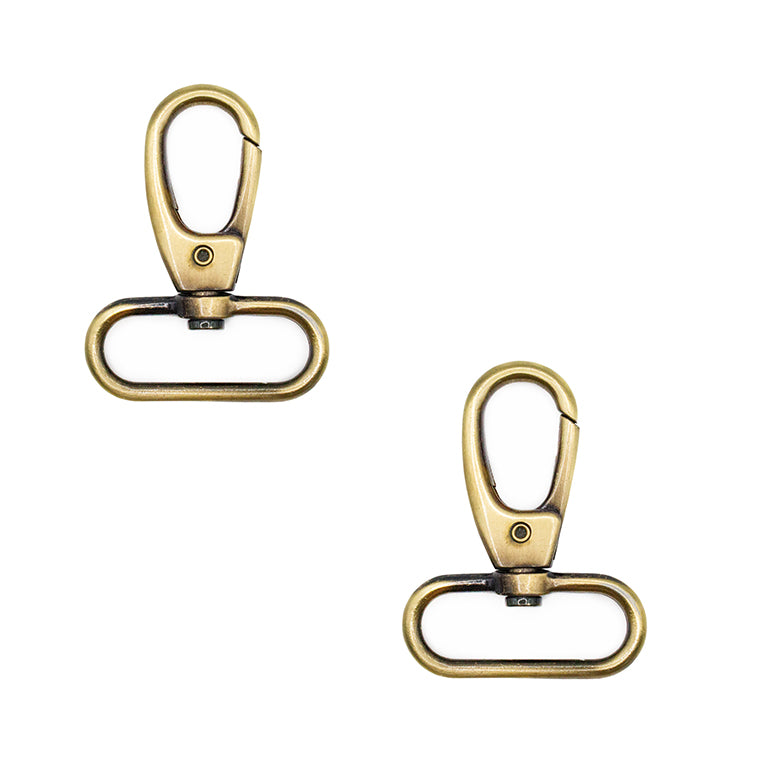 Two antique gold tone oval ring swivel clasps on a white background.