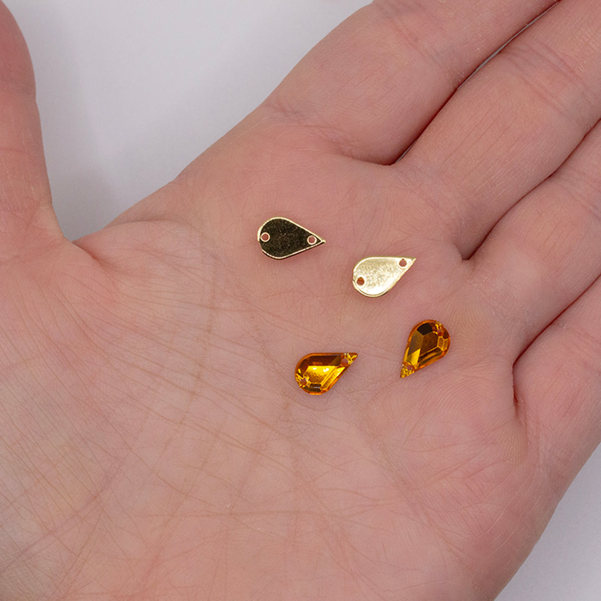 Close-up of a single 6x10mm amber gold teardrop rhinestone.