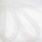 Uneven shaped white trim elastic displayed on a table