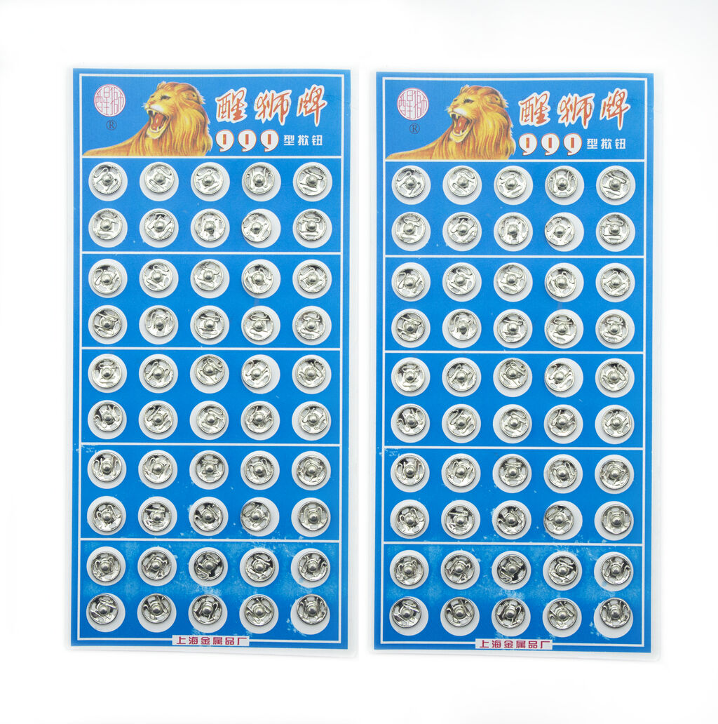 Close-up of silver metal clip buttons, 8mm wide, for sewing projects.