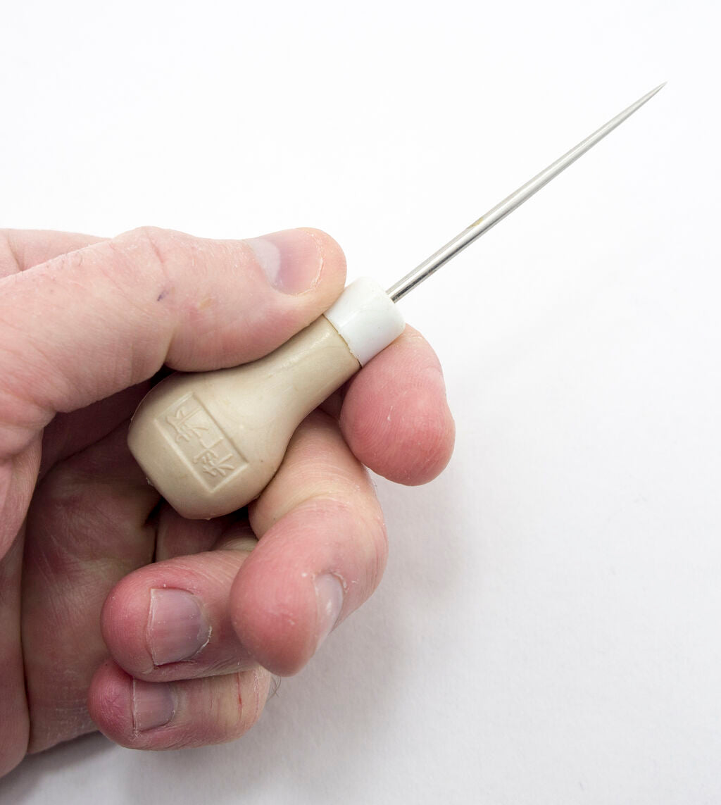 Close-up of a plastic le clickers awl, showcasing its sharp blade and handle.