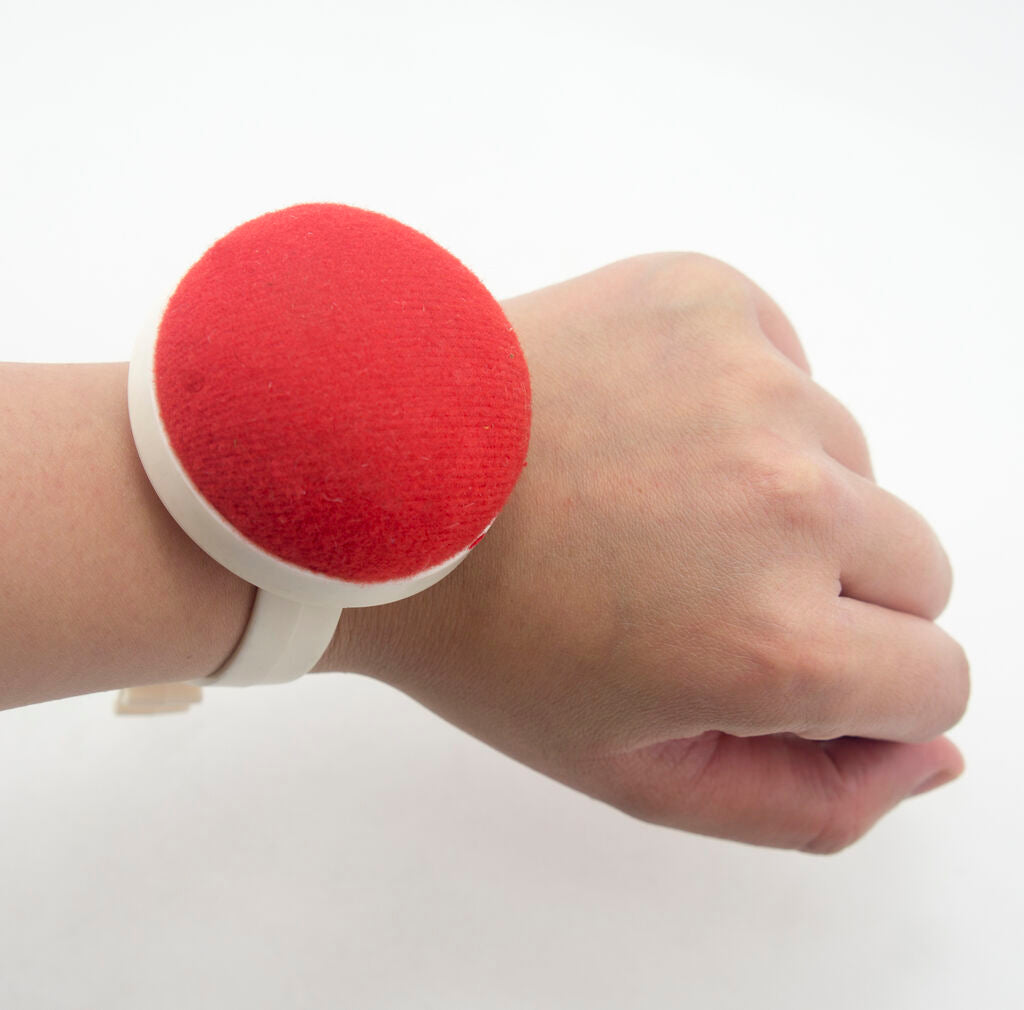 Wrist pin cushion being used while sewing fabric.