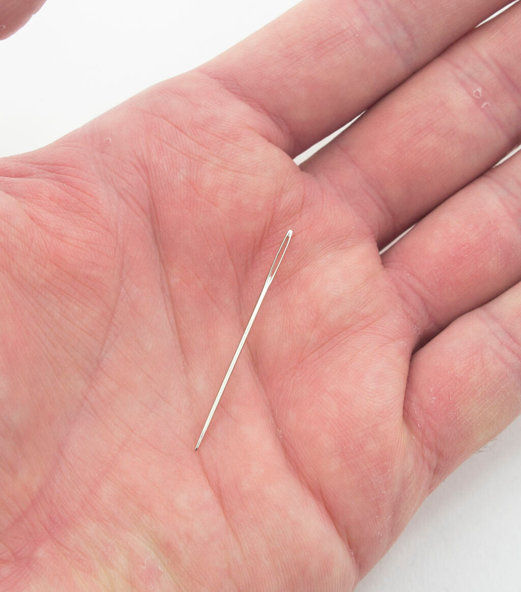 Close-up of cross stitching needles with large openings for easy threading.