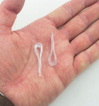 Large plastic garment shirt clips displayed on a fabric background.