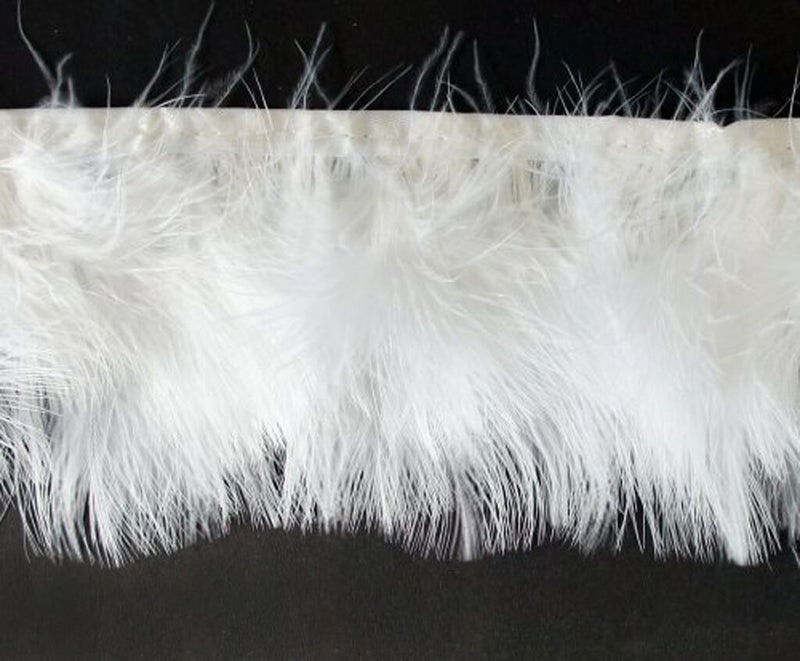 Close-up of white goose feather fringe trim on a roll.