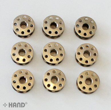 Nine metal bobbins arranged neatly on a white background.