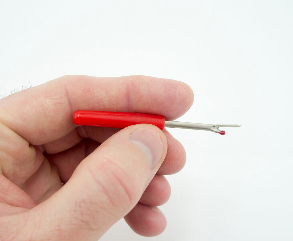 Close-up of the unpicker's sharp blade designed for precision cutting.