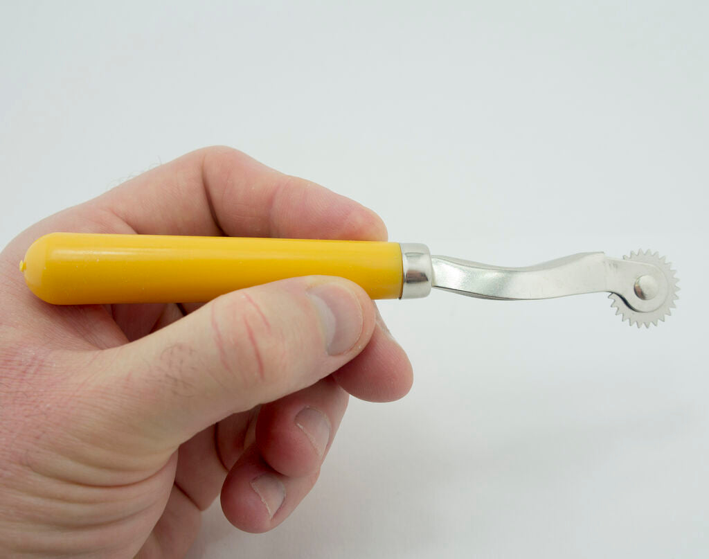 Close-up of the serrated edge of the tracing wheel for accurate marking.
